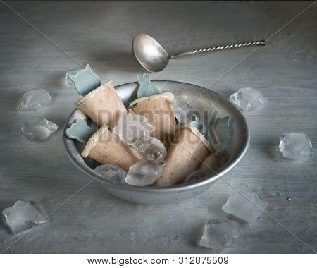 Homemade Fruit Ice Cream In A Deep Aluminum Plate With Pieces Of Ice On A Light Table