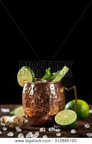 Famous splashing Moscow mule alcoholic cocktail in copper mugs, freeze motion effect.
