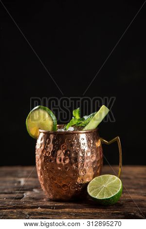 Famous splashing Moscow mule alcoholic cocktail in copper mugs, freeze motion effect.