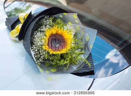 A Bouquet Of Sunflower On A White Car
