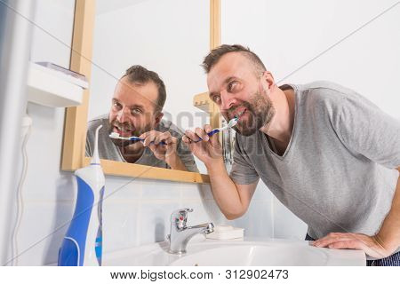 Funnny Guy Taking Care Of His Oral Hygiene, Brushing Teeth During Morning Bathroom Routine.