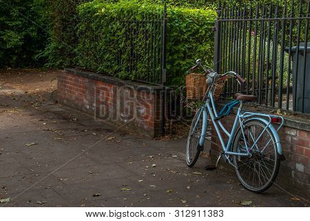 London - May 5, 2019 - A Bicycle Parked On The Sidewalk In Front Of Old Red Brick Lofts In The City 