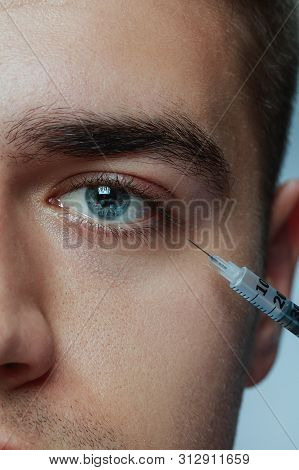 Close-up Portrait Of Young Man Isolated On Grey Studio Background. Filling Surgery Procedure. Concep