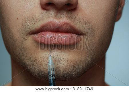 Close-up Portrait Of Young Man Isolated On Grey Studio Background. Filling Surgery Procedure. Concep