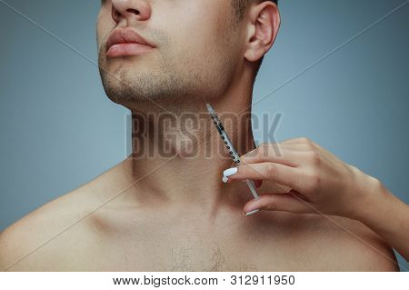 Close-up Portrait Of Young Man Isolated On Grey Studio Background. Filling Surgery Procedure. Concep