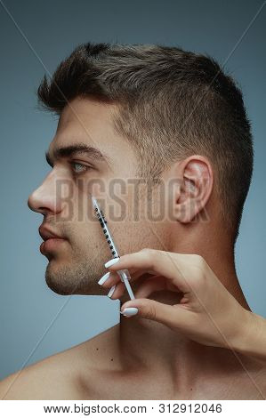 Close-up Profile Portrait Of Young Man Isolated On Grey Studio Background. Filling Surgery Procedure