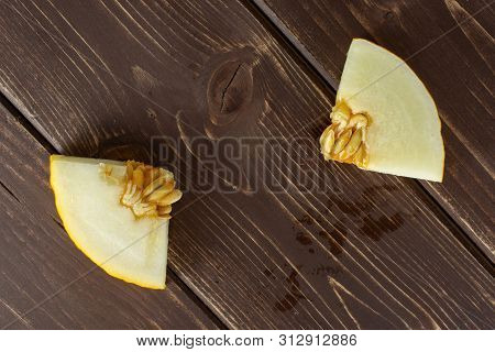 Group Of Two Pieces Of Fresh Yellow Melon Canary Flatlay On Brown Wood