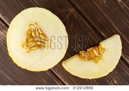 Group Of One Half One Slice Of Fresh Yellow Melon Canary Flatlay On Brown Wood