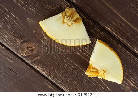 Group Of Two Pieces Of Fresh Yellow Melon Canary Flatlay On Brown Wood