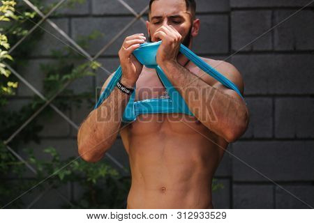 Handsome Bodybuilder In Blue Singlet Posing Outside. Bearden Men Before Training