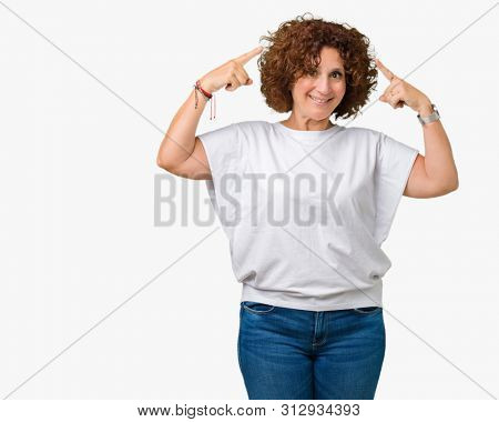 Beautiful middle ager senior woman wearing white t-shirt over isolated background Smiling pointing to head with both hands finger, great idea or thought, good memory