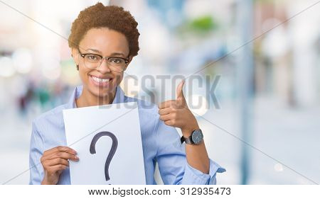 Young african american woman holding paper with question mark over isolated background happy with big smile doing ok sign, thumb up with fingers, excellent sign