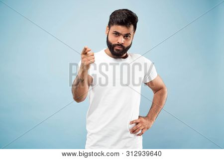 Half-length Close Up Portrait Of Young Hindoo Man In White Shirt On Blue Background. Human Emotions,