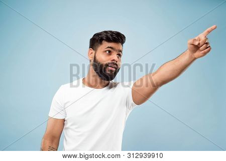 Half-length Close Up Portrait Of Young Hindoo Man In White Shirt On Blue Background. Human Emotions,