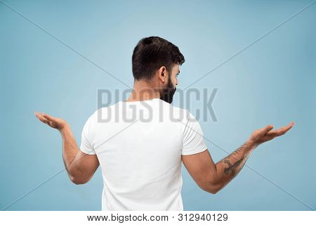 Half-length Close Up Portrait Of Young Hindoo Man In White Shirt On Blue Background. Human Emotions,