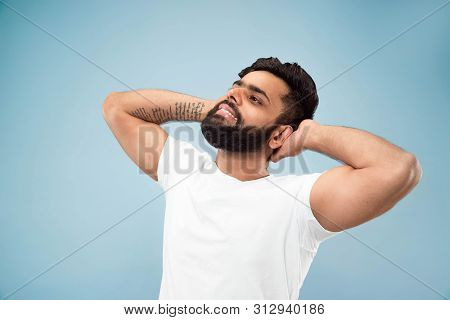 Half-length Close Up Portrait Of Young Hindoo Man In White Shirt On Blue Background. Human Emotions,