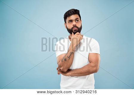 Half-length Close Up Portrait Of Young Hindoo Man In White Shirt On Blue Background. Human Emotions,