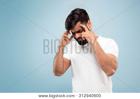 Half-length Close Up Portrait Of Young Hindoo Man In White Shirt On Blue Background. Human Emotions,