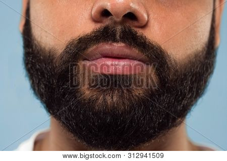 Close Up Portrait Of Young Hindoo Mans Face With Beard And Lips On Blue Background. Looking Calm. Hu