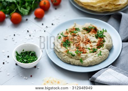 Eggplant Dip Baba Ganoush (mutabbal) With Herbs And Paprika On Gray Wooden Background. Selective Foc