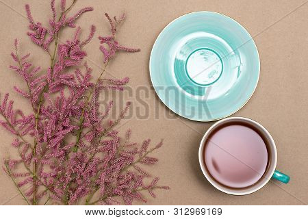 Cup Of Hot Tea And A Tamarix Gallica Tree Branches On A Brown Background.
