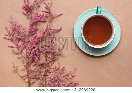Cup Of Hot Tea And A Tamarix Gallica Tree Branches On A Brown Background.