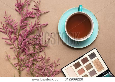 Make Up Concept Flat Lay Background. Make Up Brushes And Cosmetics, Cup Of Tea And A Blooming Tamari
