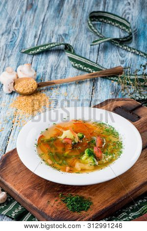 Vegetable Brot, Soup With Broccoli, Asparagus, Carrots, Onions, Bell Peppers And Greens In A White P