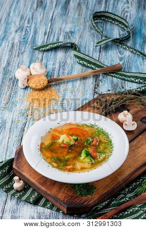 Vegetable Brot, Soup With Broccoli, Asparagus, Carrots, Onions, Bell Peppers And Greens In A White P