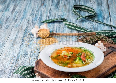 Vegetable Brot, Soup With Broccoli, Asparagus, Carrots, Onions, Bell Peppers And Greens In A White P