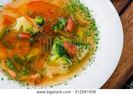 Vegetable Brot, Soup With Broccoli, Asparagus, Carrots, Onions, Bell Peppers And Greens In A White P