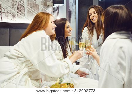 Young Women In White Bathrobe With Champagne Glasses At A Spa Party