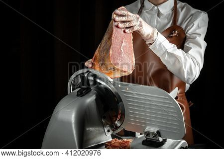 Dry Spanish Ham On Cutting Machine, Jamon Serrano, Iberian Ham Cutter On Black Background.