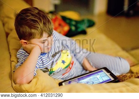 Little School Kid Boy Making Homework With Tablet. Schoolchild Reading And Learning With Computer, S