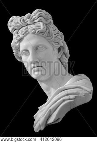 God Apollo bust sculpture. Ancient Greek god of Sun and Poetry Plaster copy of a marble statue isolated on black