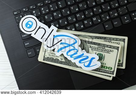 Kharkov, Ukraine - February 14, 2021: Onlyfans Paper Logo And Dollar Bills On Black Laptop Keyboard.