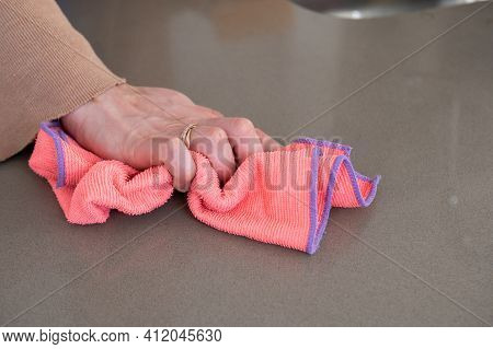 Close Up Of A Woman's Hands Wiping A Kitchen Counter Top With A Colorful Rag.cleaning And Hygiene Co
