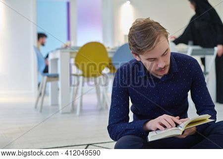 Young muslim man reading Quran during Ramadan