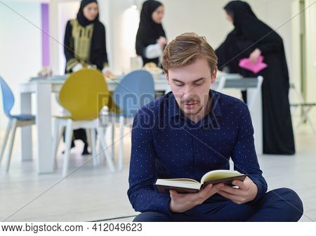 Young muslim man reading Quran during Ramadan