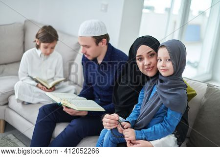 Young muslim family reading Quran during Ramadan