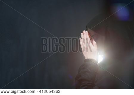 Portrait of young Muslim woman making dua