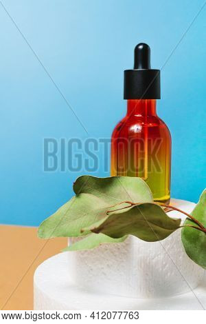 Cosmetic Bottle With Pipette On Blue And Bige Background. Face, Anti Age Skin Care Treatment On Podi