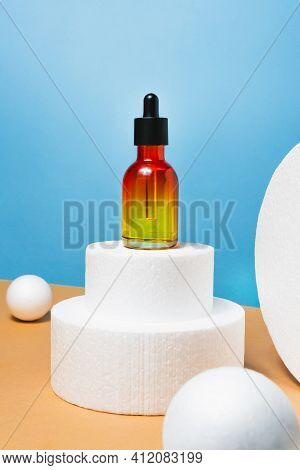 Bottle With Pipette Essential Oil, Serum On Blue And Bige Background. Face, Skin Care Organic Beauty