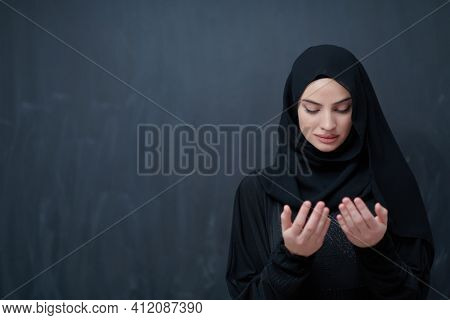Portrait of young Muslim woman making dua
