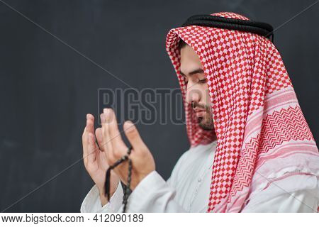 Arab man in traditional clothes praying to God or making dua