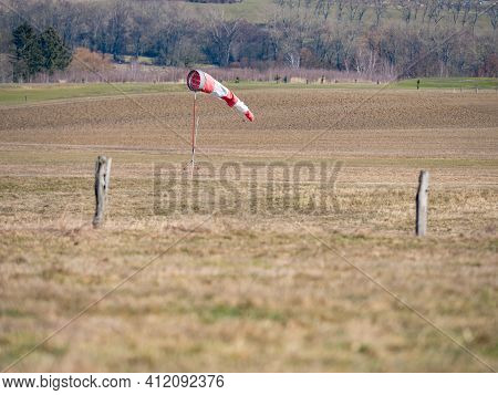 Worn Out Windsock On Abandoned Sport Airport.  The Wind Is Blowing Lazy And Windsock Is Turning And 
