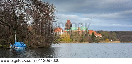 Lake Of Ratzeburg With Blue Boat And Cathedral (ratzeburger Dom) With Construction Scaffolding At Th