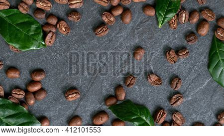 Falling Roasted Coffee Beans on Black Stone Background, close-up.