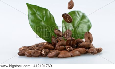 Falling Roasted Coffee Beans on White Background, close-up.