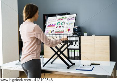 Adjustable Height Desk Stand In Office Using Computer